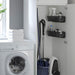 Laundry room with washing machine, cleaning supplies, and a cabinet.