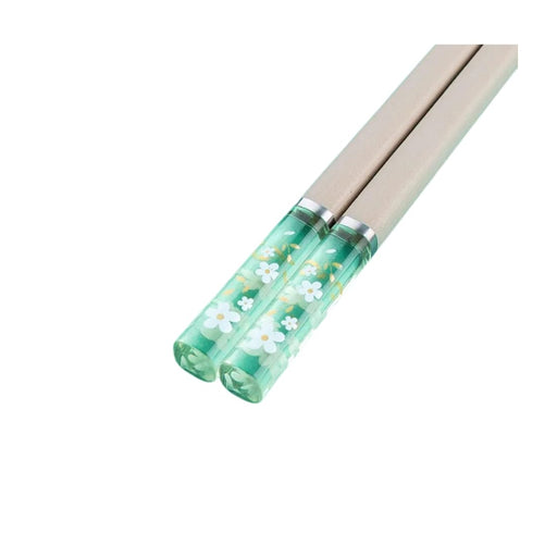 Chopsticks with floral design on a green casing on a white background