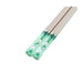 Chopsticks with floral design on a green casing on a white background