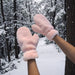 raised arms wearing pink furry gloves in snowy forest scene