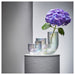 Decorative vase with a purple flower on a gray background