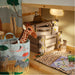 Children's room with toy storage bins, a stuffed giraffe, and a tote bag with animal designs.