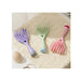 Three pet grooming tools in purple, green, and pink on a textured surface.