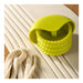 Green pasta press on a surface with uncooked pasta strands