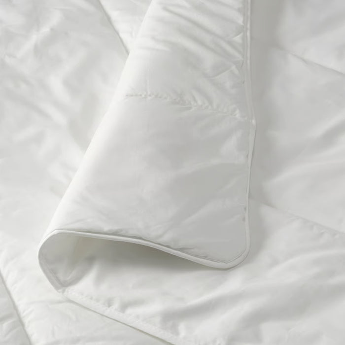 Close-up of IKEA STJÄRNBRÄCKA warm white duvet, 150x200 cm, showing quilted stitching and folded corner to highlight thickness and soft texture – 00458089