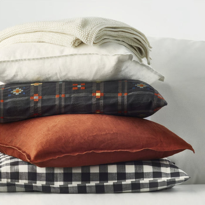 Stack of pillows with different patterns on a light background