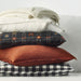 Stack of pillows with different patterns on a light background