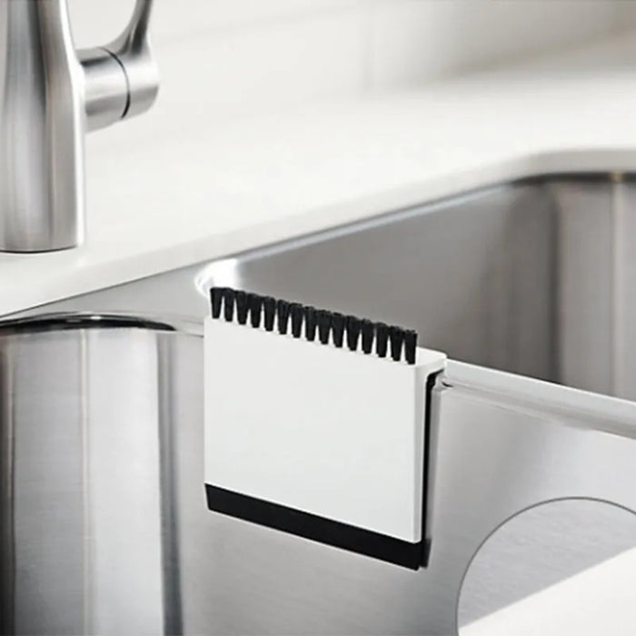 Close-up of a kitchen faucet with a soap dispenser attachment.