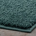Close-up of a Turquoise Bathmat on a wooden floor