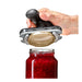 Hand using black-handled jar opener to twist open glass jar of red fruit preserves – ergonomic grip for sealed lids – 1600004084340 13927404