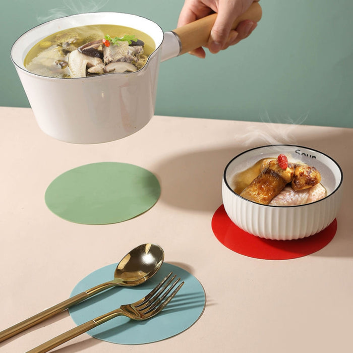 round silicone mat protecting wooden table from hot cookware