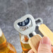 Wooden bottle opener with a heart-shaped bottle cap remover on a gray background
