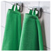 Two green towels hanging on a silver towel rack against a tiled wall.