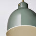 Close-up of RÖDFLIK pendant lamp showing brass fitting, toggle switch detail, and muted green conical top section