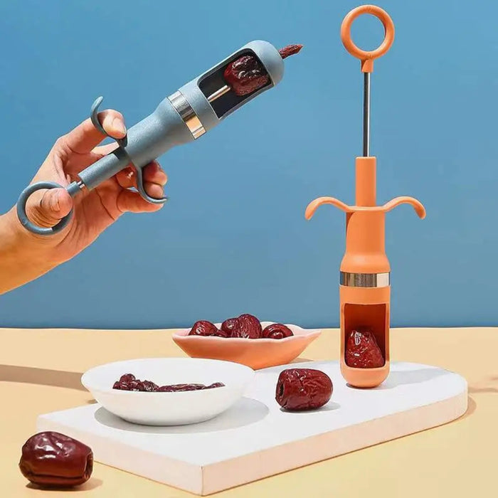 Two jujube seed removers with plunger design shown in action and upright, alongside dates and serving dishes