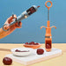 Two jujube seed removers with plunger design shown in action and upright, alongside dates and serving dishes