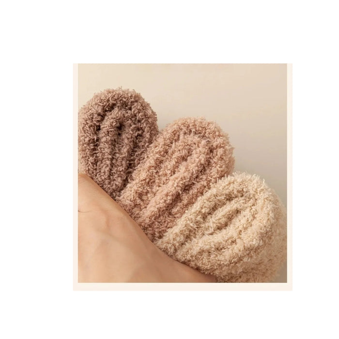 Pair of fluffy socks on a beige background