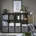 Modern living room with a dark bookshelf, books, and decorative items.