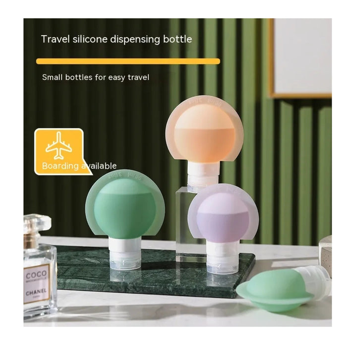 Travel silicone dispensing bottles with a green bottle cap on a marble surface.