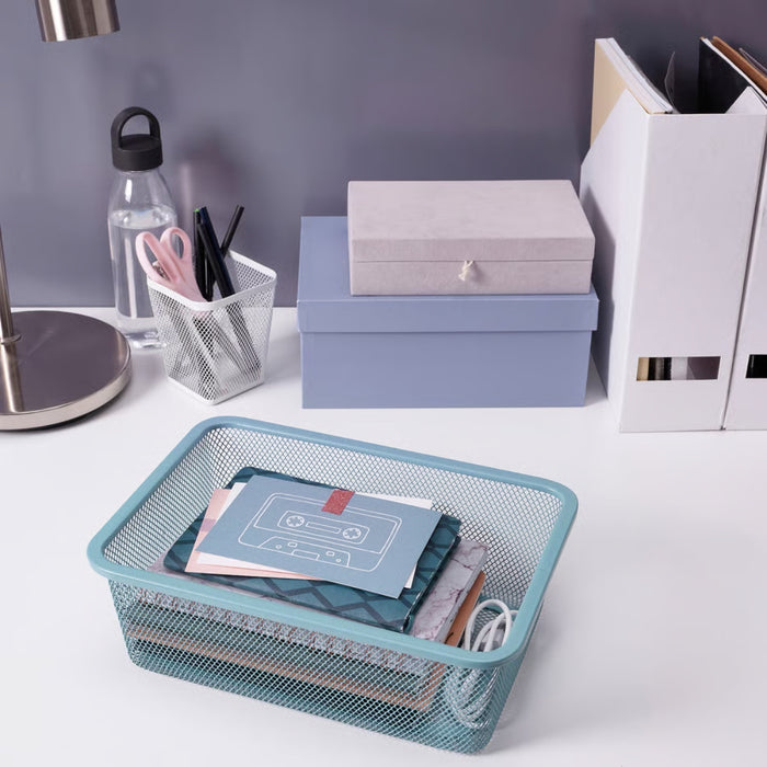 TROFAST mesh basket placed on a clean desk with notebooks, pen holders, and file organizers in a minimal workspace