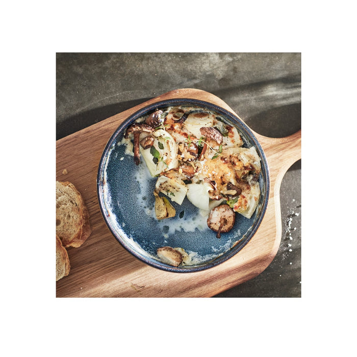 Blue bowl with food on a wooden cutting board