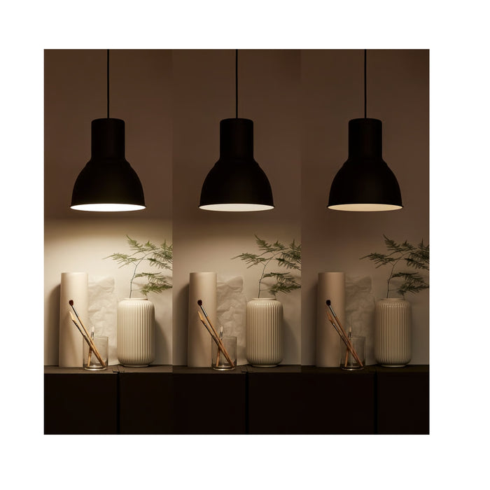 Three black pendant lights hanging above a decorative setup with plants and candles.