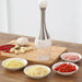 Kitchen setting showing the multifunctional crusher alongside fresh garlic, chilies, and bowls of finely minced ingredients.