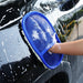 Person cleaning a car with a blue sponge