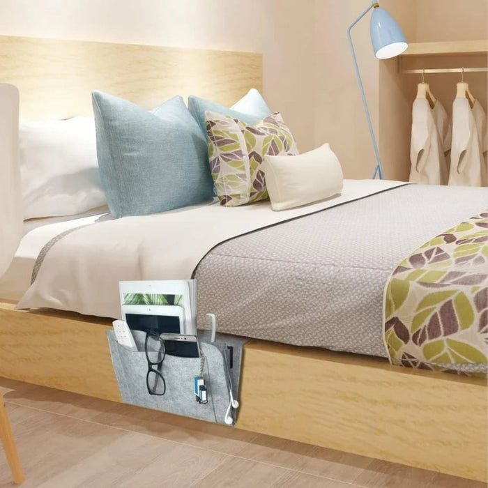Bedroom with a bed and a bedside caddy holding books and other items.
