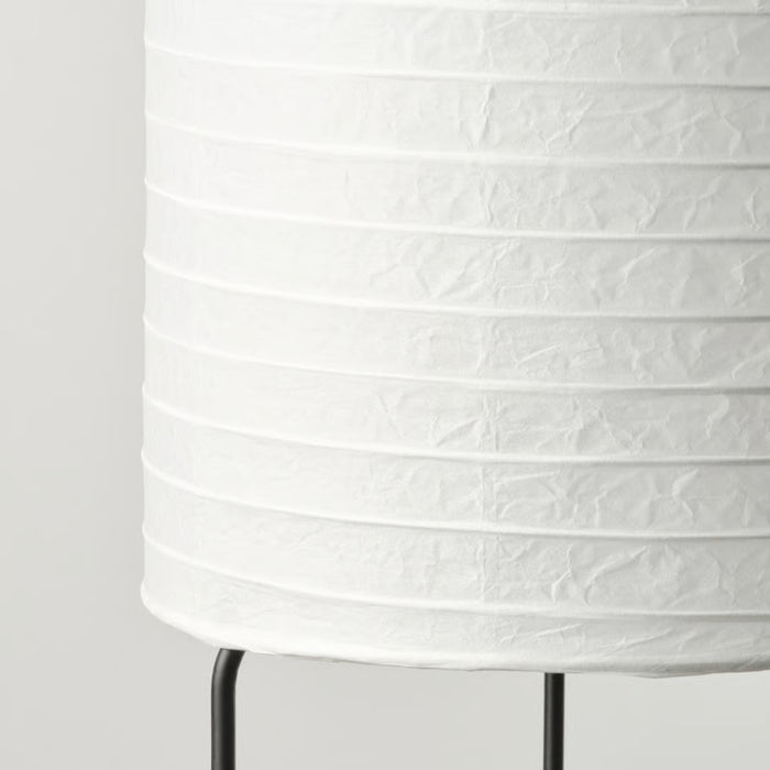 Close-up of IKEA STRANDAD floor lamp with white crinkled paper shade and black metal frame, highlighting textured ridges and minimalist design – 50594838