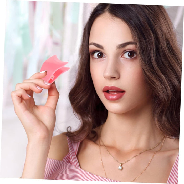 Woman holding a pink facial mask with a blurred background
