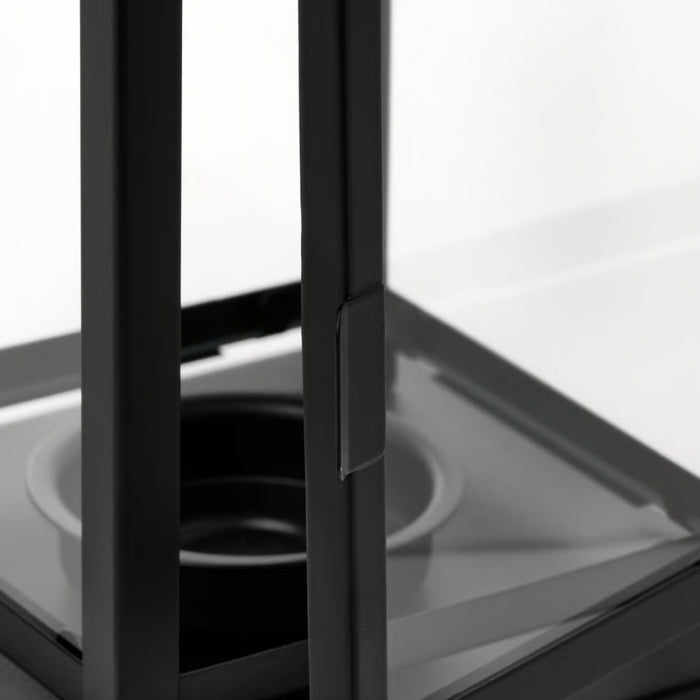 Close-up of a black metal frame with glass panels on a white background
