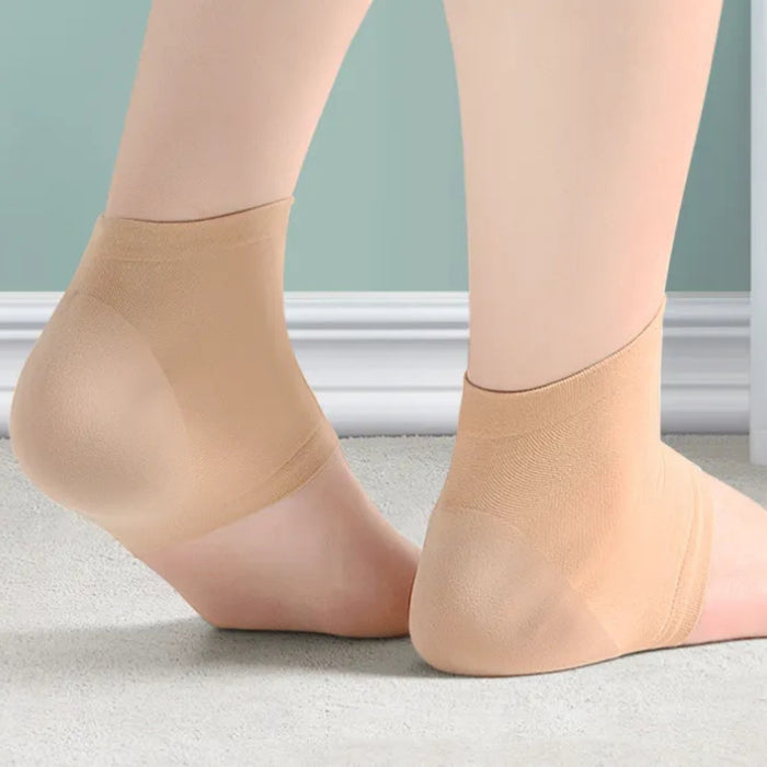 Beige socks worn by a person on a light gray floor with a neutral-colored wall in the background