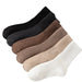 Set of four pairs of socks in black, brown, beige, and white on a white background