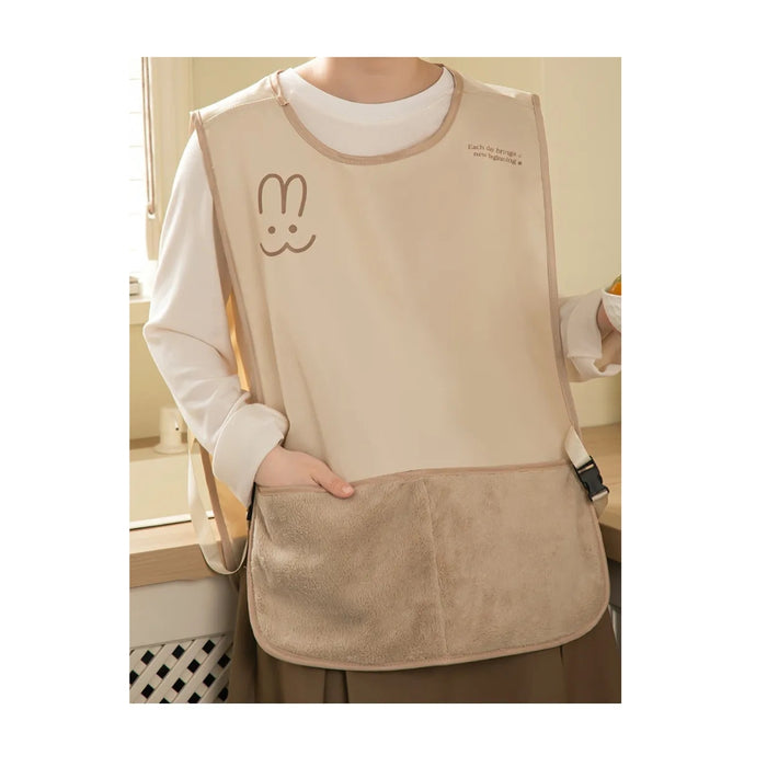 Beige apron with a cartoon bunny design worn by a person indoors.