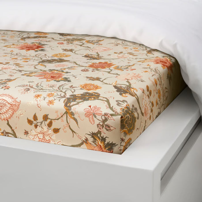 Floral patterned fitted sheet on a bed with white bedding.