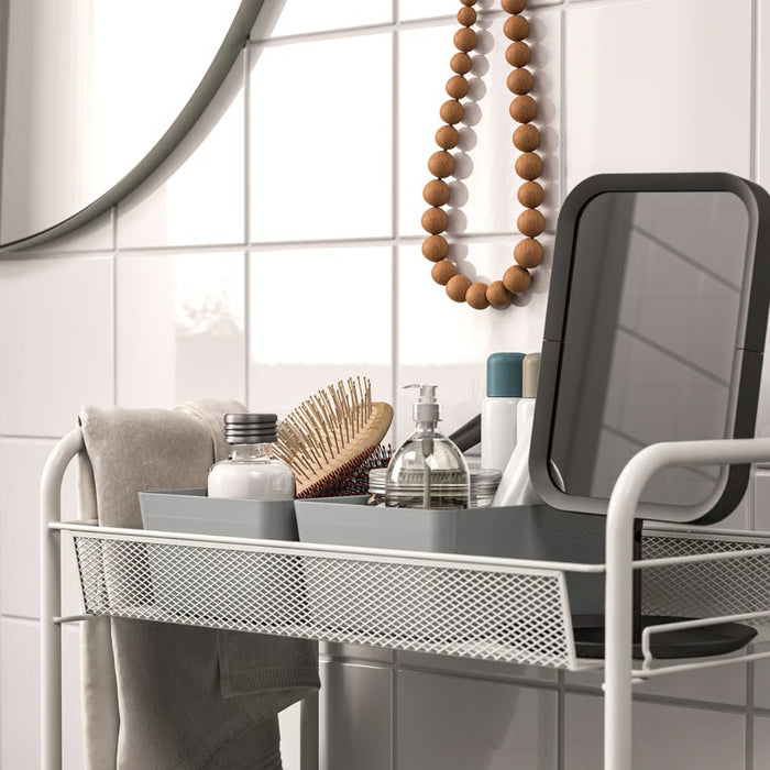 Bathroom vanity setup with a metal mesh shelf holding a gray tray with toiletries, including a pump dispenser bottle, wooden hairbrush, and small cosmetics—enhancing organized storage in a modern bathroom.-20599149