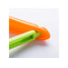 Orange vegetable peeler cutting through a green vegetable on a white background