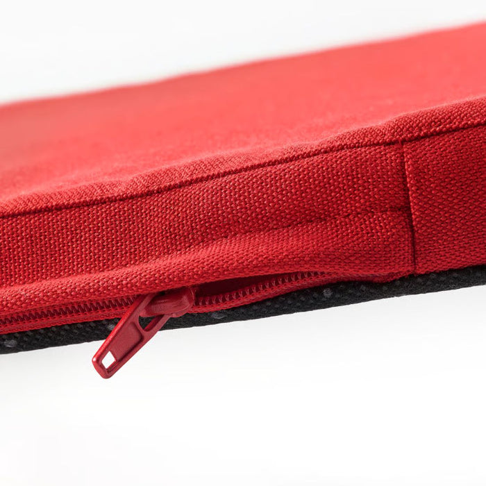 Detail view of STAGGSTARR zipper and stitching, revealing black inner lining beneath red fabric