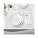 Dining table setting with white plates, glasses, and cutlery on a placemat.