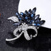 Crystal brooch – placed on black surface with layered blue stones and sparkling stem