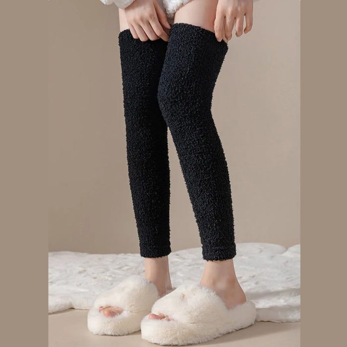 Person standing in black plush leg warmers and white slippers on cozy white rug - 