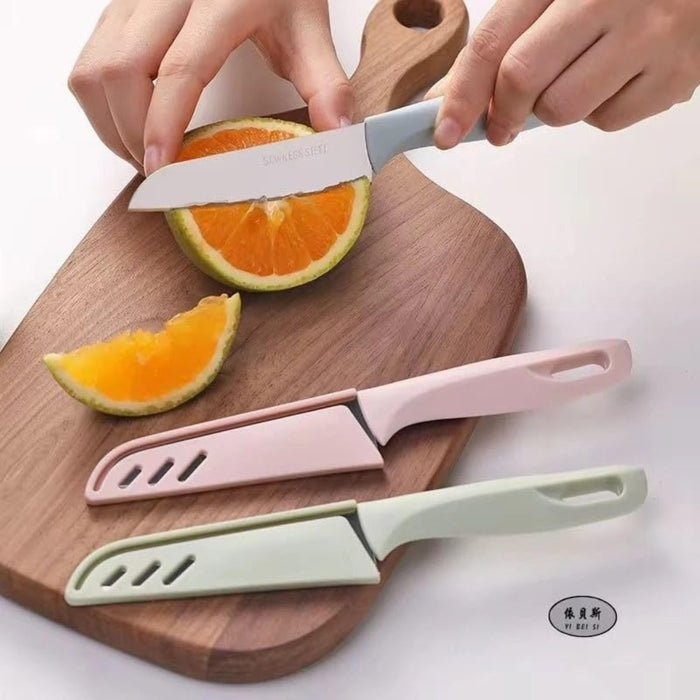 Three colorful Peeling Fruit Knifes on a wooden cutting board with an orange being sliced.