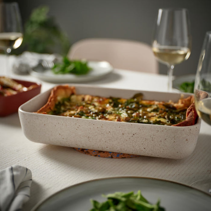 IKEA LYCKAD Oven/serving dish set of 2, light beige/red-brown, served on dining table with lasagna and wine glasses - 90607952