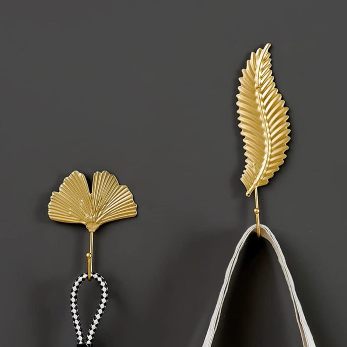 Gold leaf hooks – mounted in bathroom holding white towels beside ceramic sink