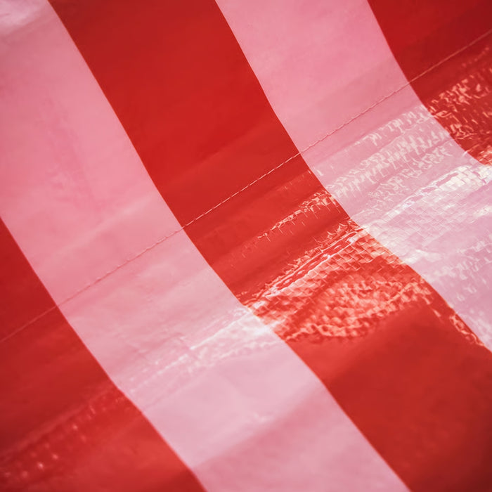 Close-up of the durable and water-resistant synthetic material of the pink and bright red striped potting mat.