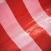Close-up of the durable and water-resistant synthetic material of the pink and bright red striped potting mat.