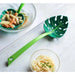 Green leaf-shaped ladle with pasta and noodles on a white surface
