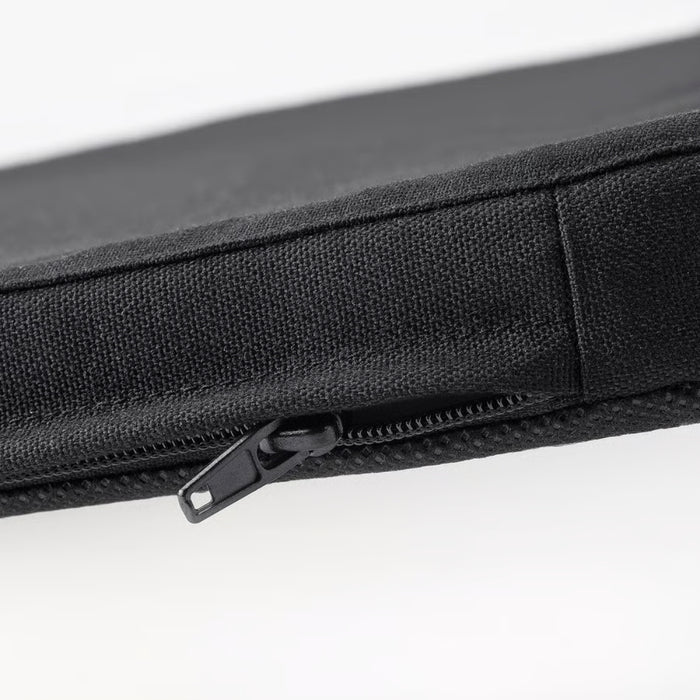 Detail view of STAGGSTARR zipper and stitching, revealing inner lining beneath durable black fabric