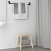 IKEA TISKEN towel rack – modern bathroom setup with black rack holding gray and white towels above stool 20498541